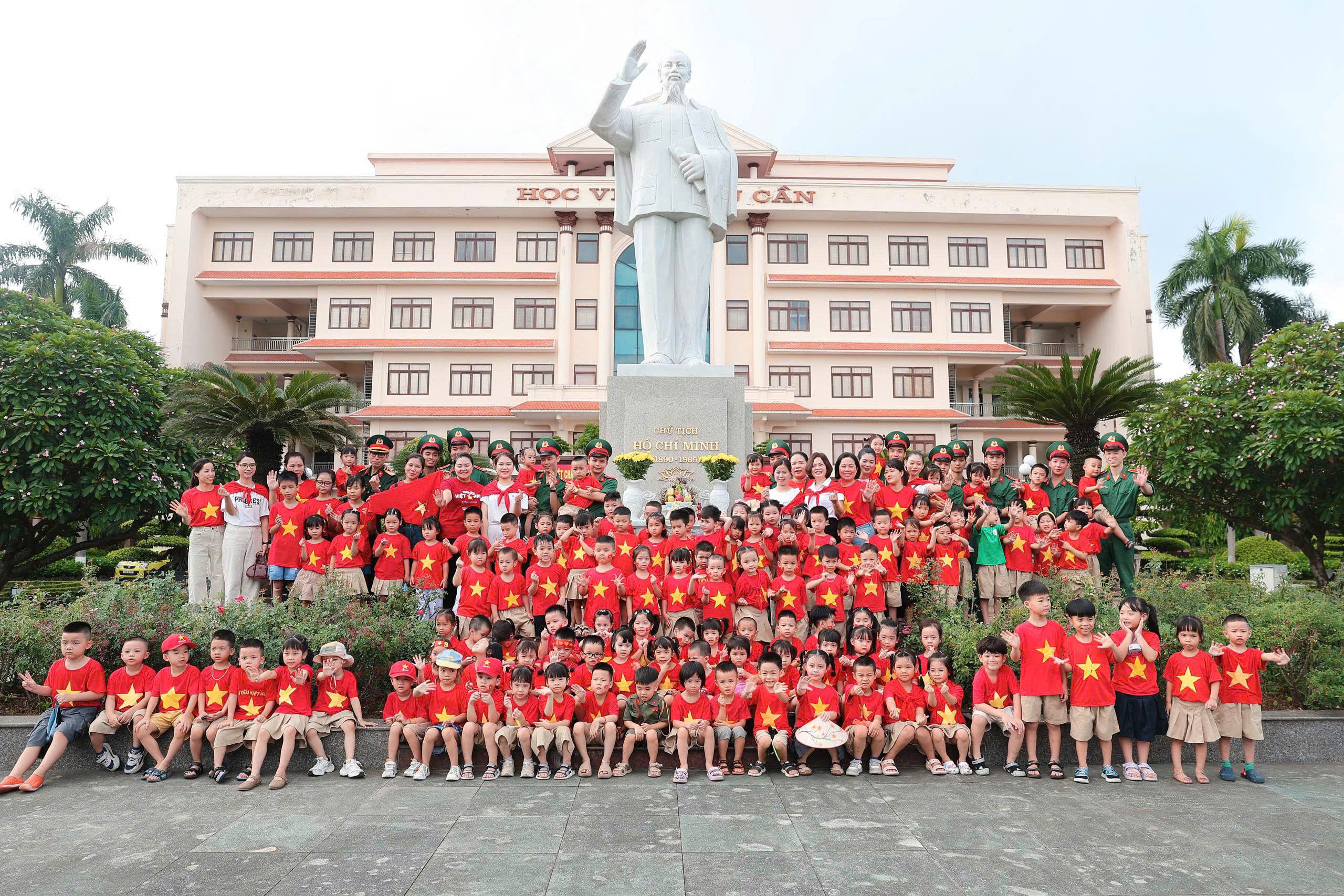 Cán bộ, học viên Học viện Hậu cần chụp ảnh lưu niệm cùng cô, trò Trường Mầm non Bắc Biên tại khuôn viên tượng đài Chủ tịch Hồ Chí Minh.
